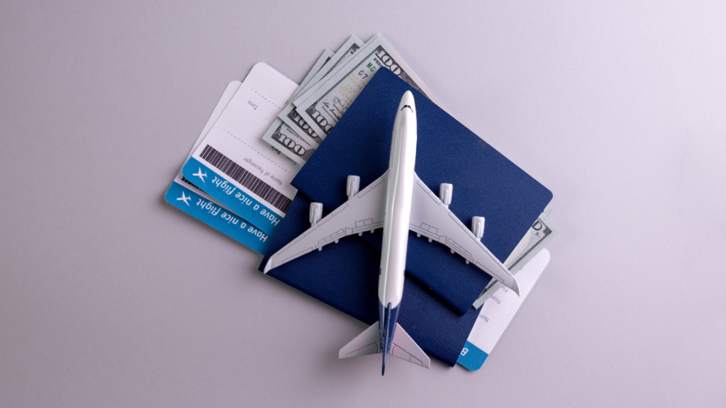 toy plane on top of flight tickets and money
