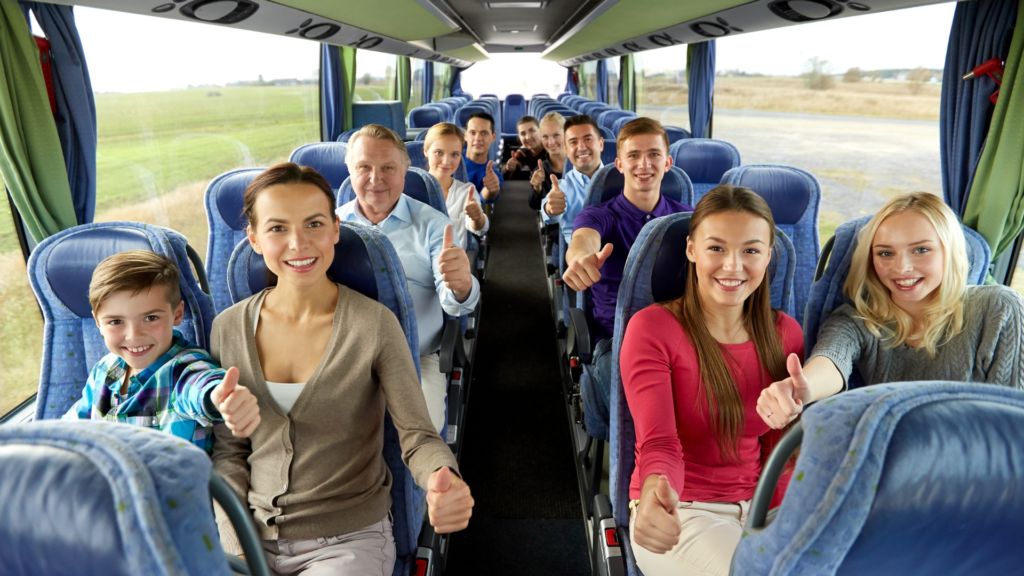 group of people in a tour bus with thumbs up