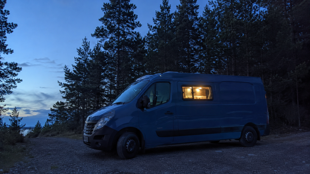 Van parked overnight at a free wild camping spot in a Scandinavian forest