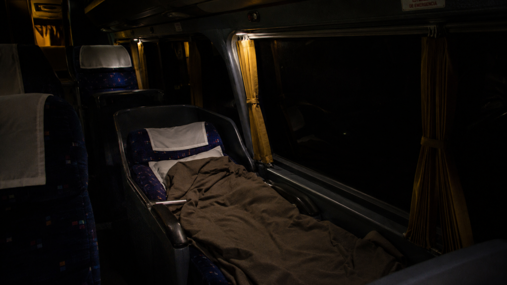Reclined cama-class seats with blankets inside a South American overnight bus"
