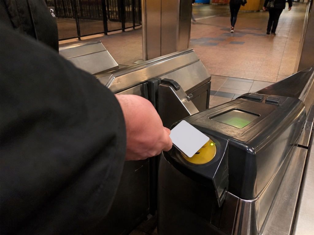 Traveller tapping a contactless card on a metro ticket gate