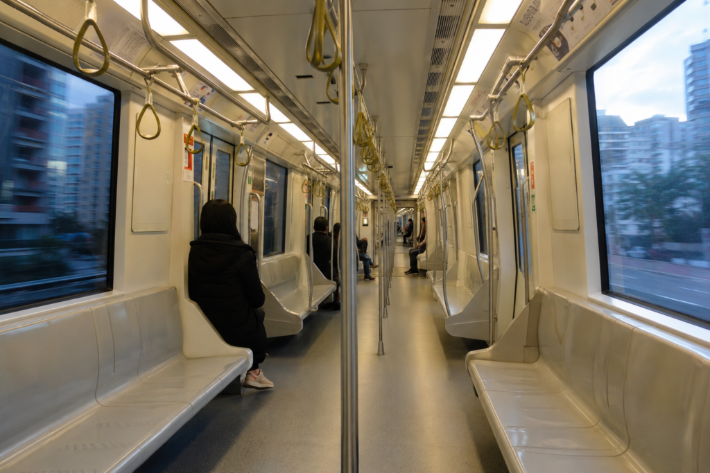 Interior of a metro carriage with passengers and city passing the windows
