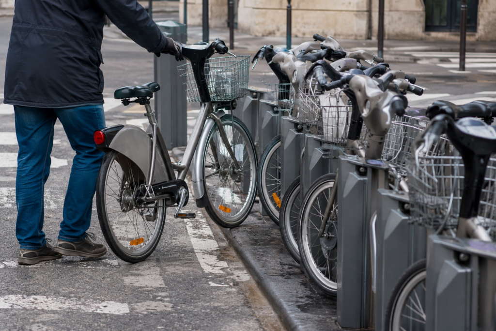Row of docked bike share bicycles with one being removed at a city docking station